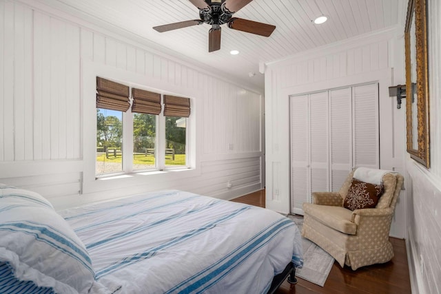 bedroom featuring a closet, wood finished floors, a ceiling fan, and ornamental molding