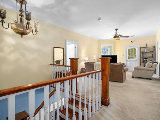 stairway featuring crown molding, carpet flooring, and ceiling fan