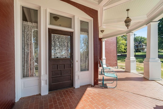 view of exterior entry featuring covered porch