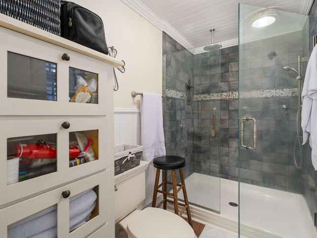 bathroom featuring toilet, a shower stall, wainscoting, and crown molding