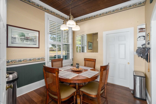 dining space with dark wood finished floors, a wainscoted wall, and wallpapered walls