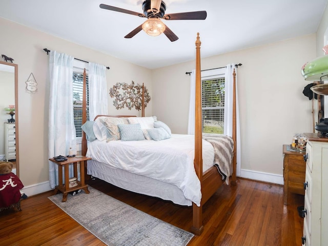 bedroom with a ceiling fan, multiple windows, wood finished floors, and baseboards