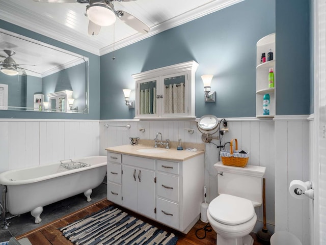 bathroom featuring toilet, wood finished floors, wainscoting, and ceiling fan