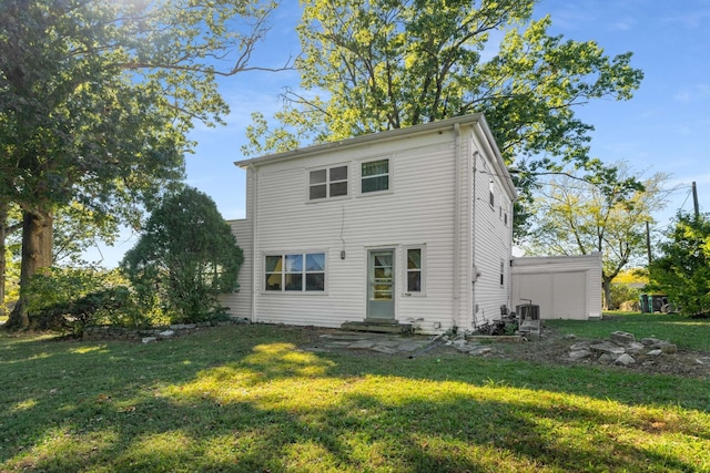 back of property with a yard, central air condition unit, and entry steps