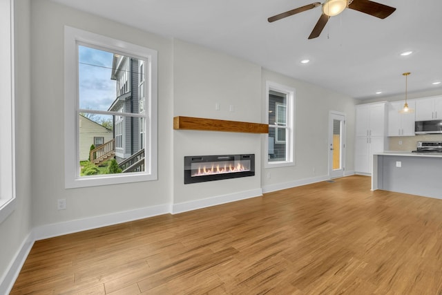 unfurnished living room featuring recessed lighting, light wood-style flooring, baseboards, and ceiling fan