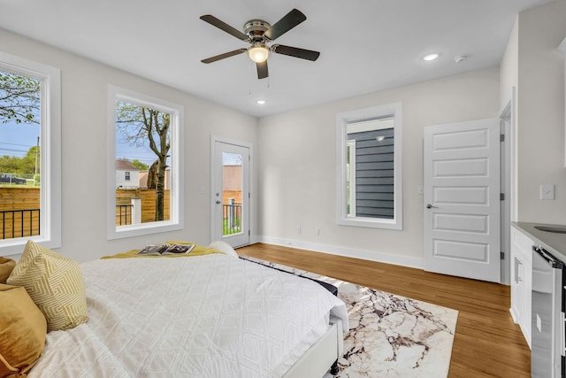 bedroom with access to exterior, baseboards, beverage cooler, recessed lighting, and wood finished floors