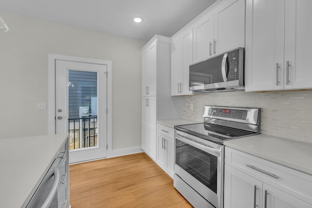 kitchen featuring decorative backsplash, light wood-style floors, white cabinetry, and stainless steel appliances