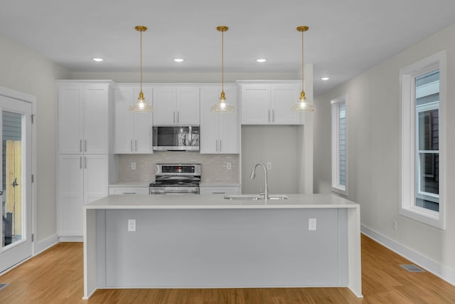 kitchen with visible vents, a sink, appliances with stainless steel finishes, white cabinets, and light countertops