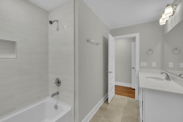 bathroom featuring tile patterned floors, shower / bathing tub combination, baseboards, and vanity