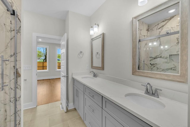 full bathroom featuring double vanity, tile patterned floors, a marble finish shower, and a sink