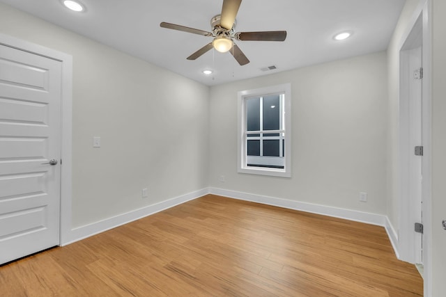 unfurnished room featuring a ceiling fan, light wood-style flooring, baseboards, and visible vents