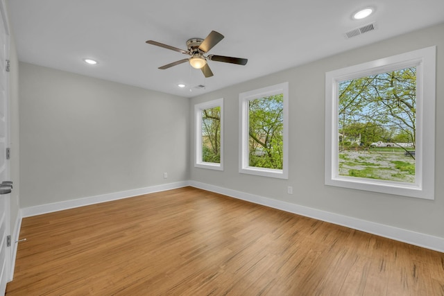 unfurnished room featuring baseboards, visible vents, light wood finished floors, and ceiling fan