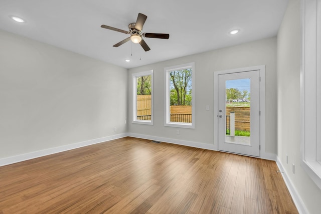 unfurnished room with ceiling fan, baseboards, plenty of natural light, and wood finished floors