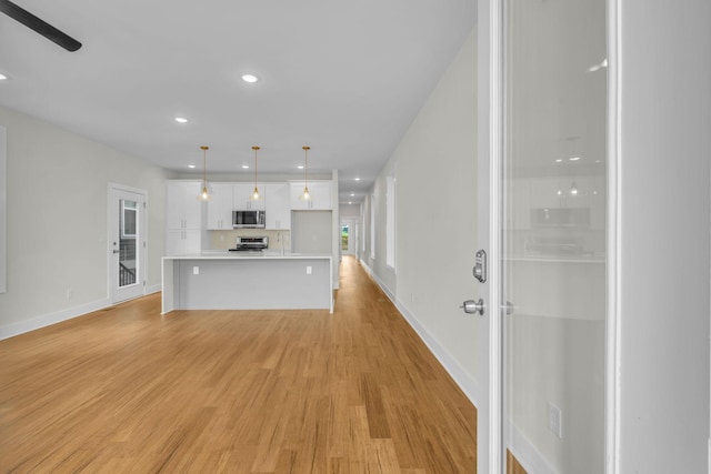 unfurnished living room featuring recessed lighting, light wood-type flooring, baseboards, and ceiling fan