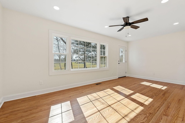 empty room featuring recessed lighting, baseboards, and light wood finished floors