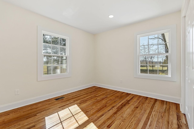 empty room featuring recessed lighting, visible vents, baseboards, and wood finished floors