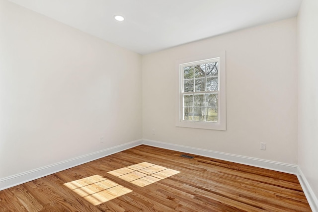 unfurnished room featuring recessed lighting, visible vents, baseboards, and wood finished floors