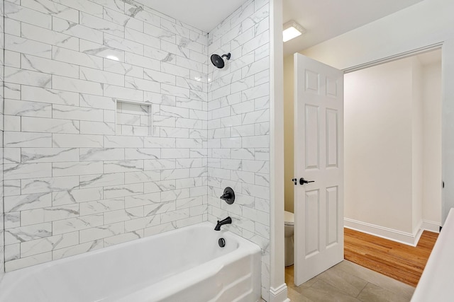 full bath featuring baseboards, toilet, wood finished floors, and shower / tub combination