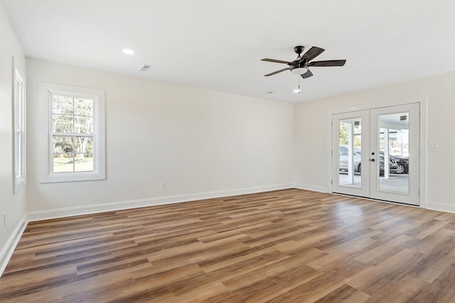 unfurnished room featuring wood finished floors, visible vents, baseboards, ceiling fan, and french doors