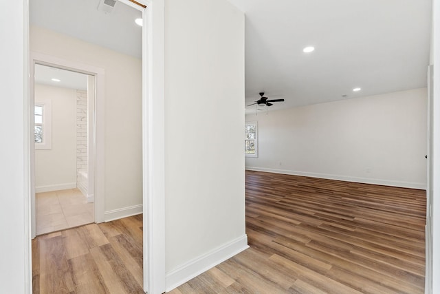 corridor featuring recessed lighting, visible vents, baseboards, and wood finished floors