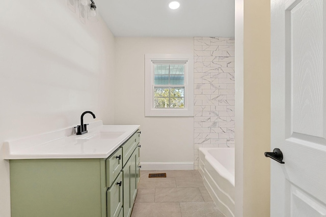 bathroom featuring visible vents, a tub, tile patterned flooring, baseboards, and vanity