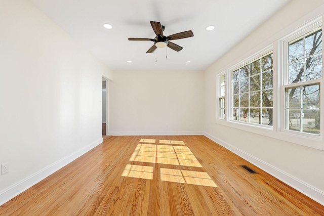 empty room featuring light wood-style flooring, recessed lighting, baseboards, and visible vents