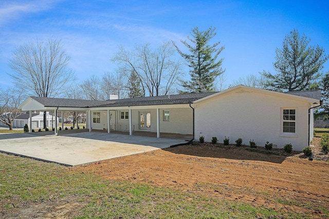 rear view of house featuring a carport, driveway, and a chimney