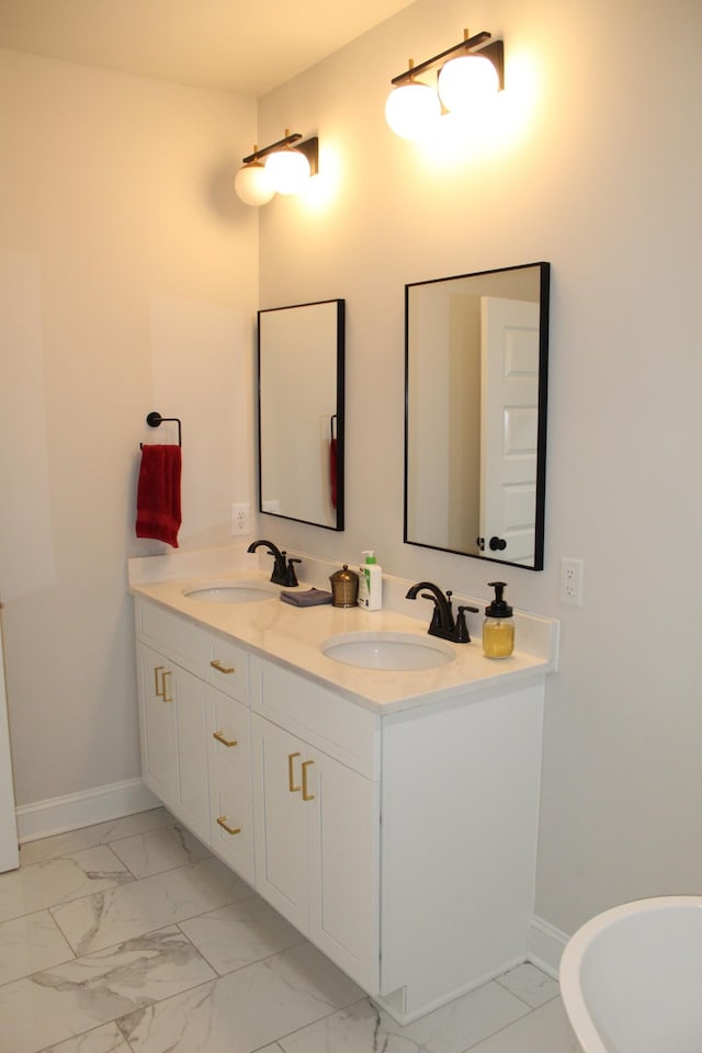 bathroom with marble finish floor, baseboards, and a sink