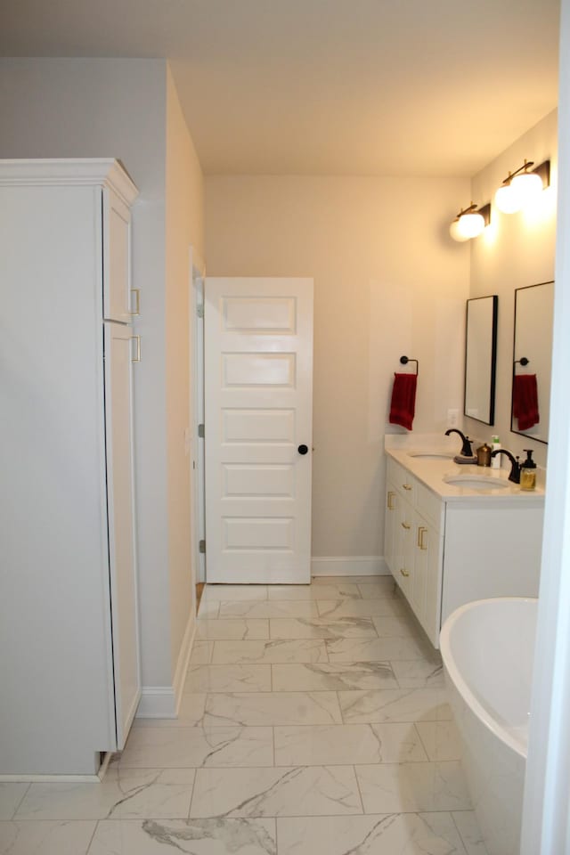 full bathroom featuring marble finish floor, baseboards, and a sink