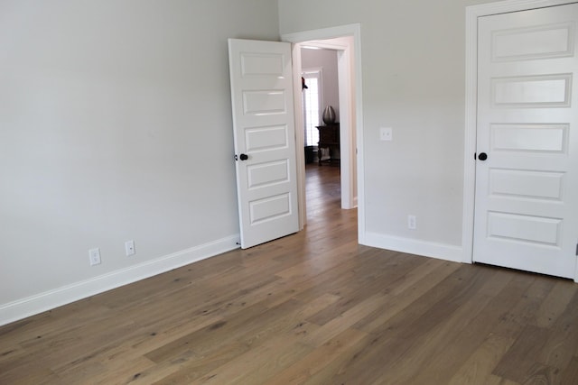 empty room with baseboards and wood finished floors