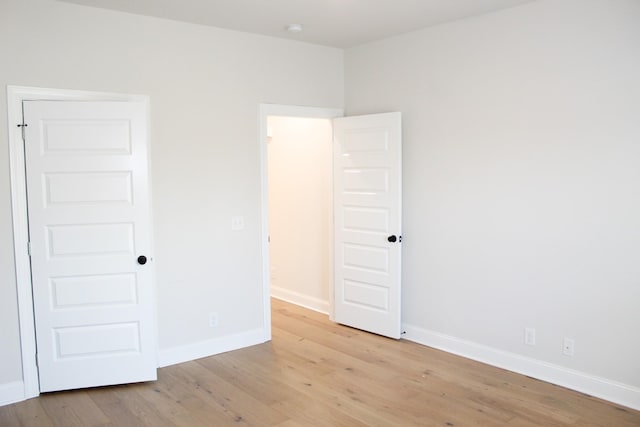 spare room with light wood-type flooring and baseboards