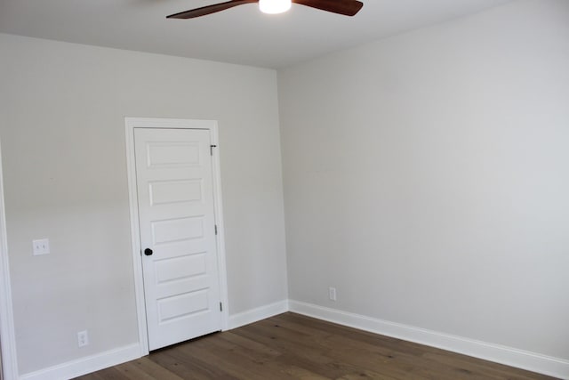 unfurnished room with a ceiling fan, baseboards, and dark wood-style flooring