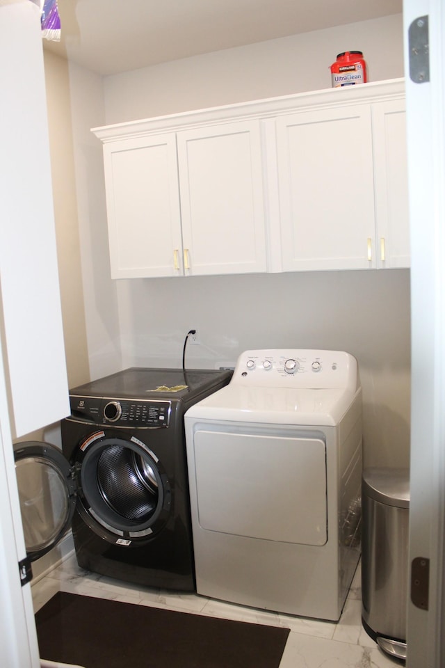 washroom featuring cabinet space, marble finish floor, and independent washer and dryer