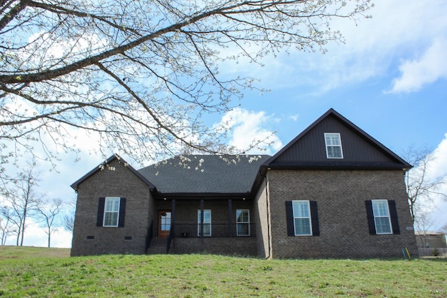 back of property featuring a yard and brick siding