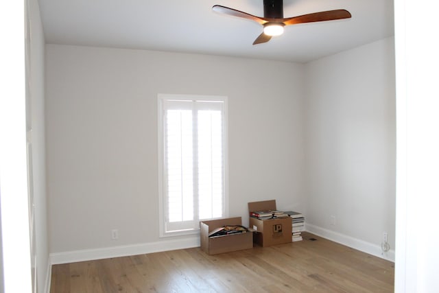 spare room featuring wood finished floors, baseboards, and ceiling fan