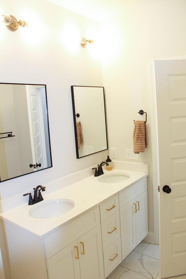 full bathroom featuring a sink, marble finish floor, and double vanity