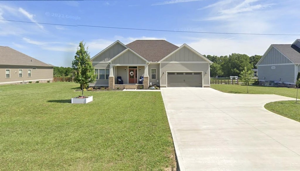 craftsman house with an attached garage, board and batten siding, concrete driveway, and a front yard