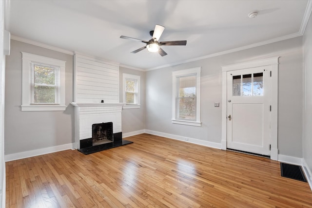 unfurnished living room with ceiling fan, light wood-style flooring, visible vents, and ornamental molding