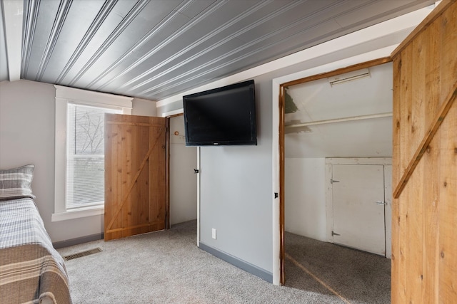 unfurnished bedroom with visible vents, lofted ceiling, and carpet flooring