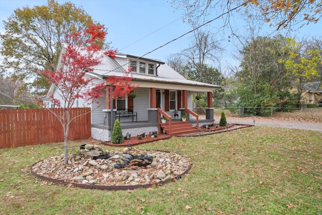 bungalow-style house featuring covered porch, fence private yard, and a front lawn