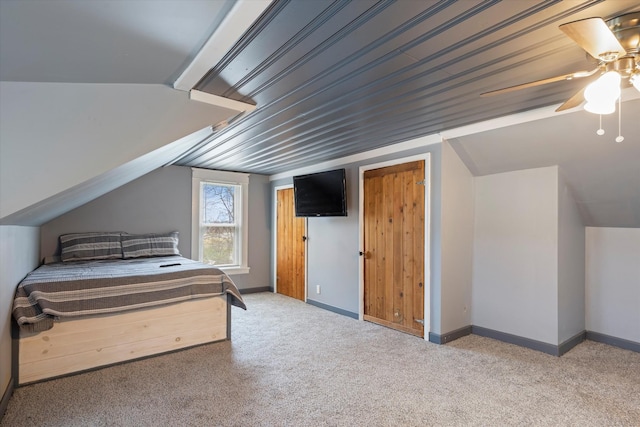 unfurnished bedroom featuring vaulted ceiling, carpet, baseboards, and ceiling fan