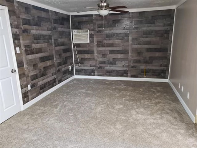 unfurnished room featuring carpet flooring, a ceiling fan, wood walls, and a textured ceiling