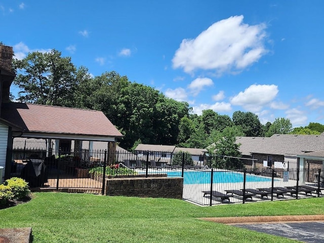 pool with a patio, a yard, and fence