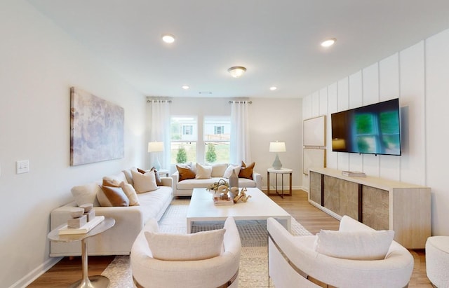 living room featuring recessed lighting, baseboards, and light wood finished floors