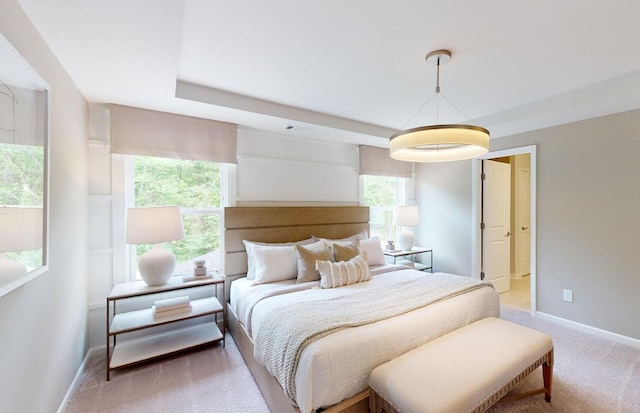 bedroom featuring light colored carpet, baseboards, and multiple windows