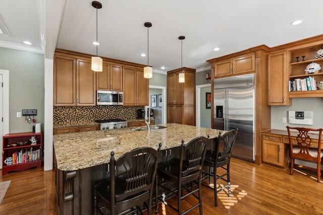 kitchen with a sink, stainless steel appliances, brown cabinets, and open shelves