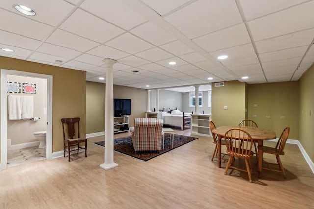 dining area with visible vents, baseboards, wood finished floors, and ornate columns