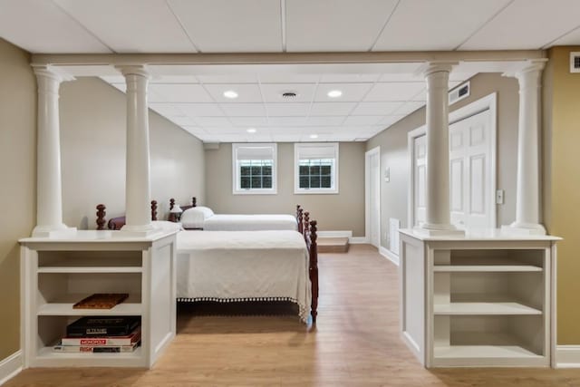 bedroom with light wood-type flooring, visible vents, a drop ceiling, recessed lighting, and baseboards