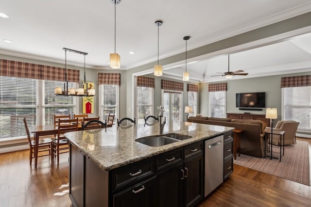 kitchen featuring a sink, dishwasher, ornamental molding, ceiling fan with notable chandelier, and a kitchen island with sink