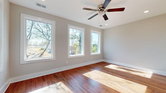 unfurnished room featuring recessed lighting, wood finished floors, visible vents, and baseboards